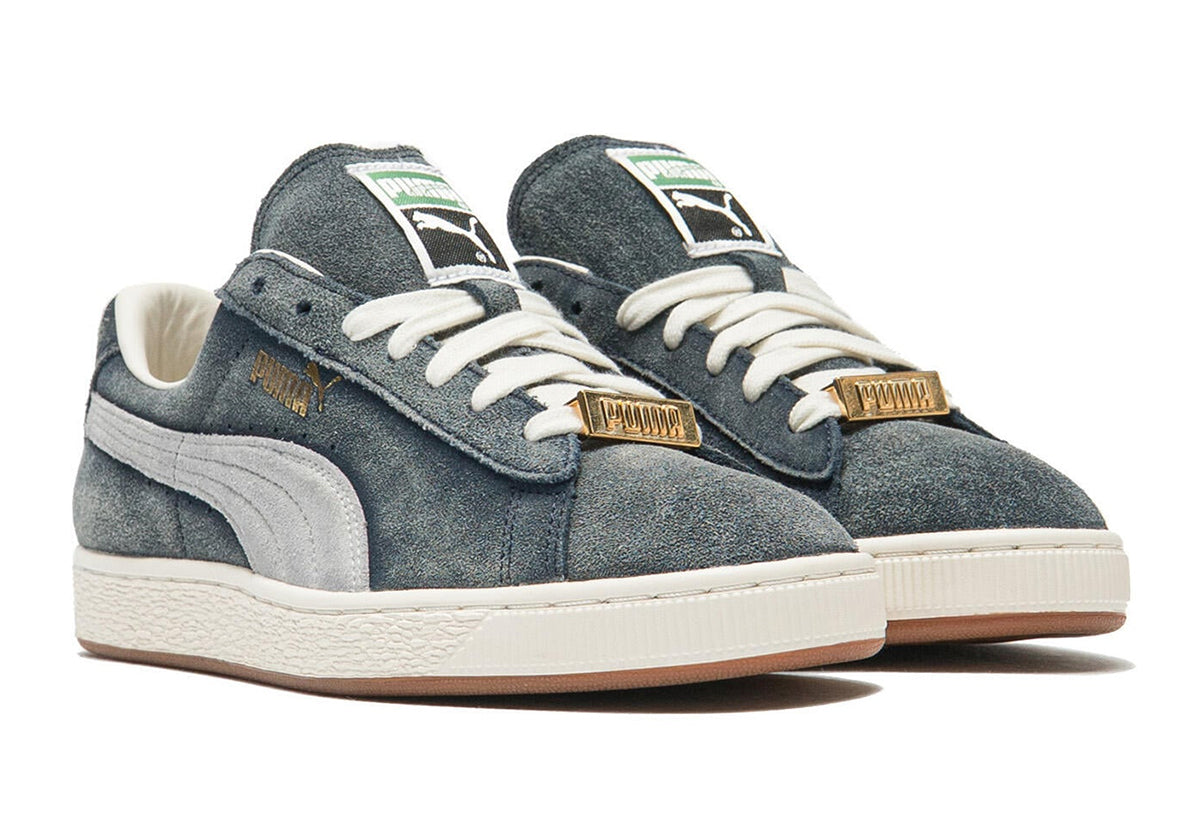 A$AP Rocky x PUMA Suede '94 Faded Blue 408735-04 pair, front angle with gold PUMA lace keepers. Retailer photo via Sneaker News