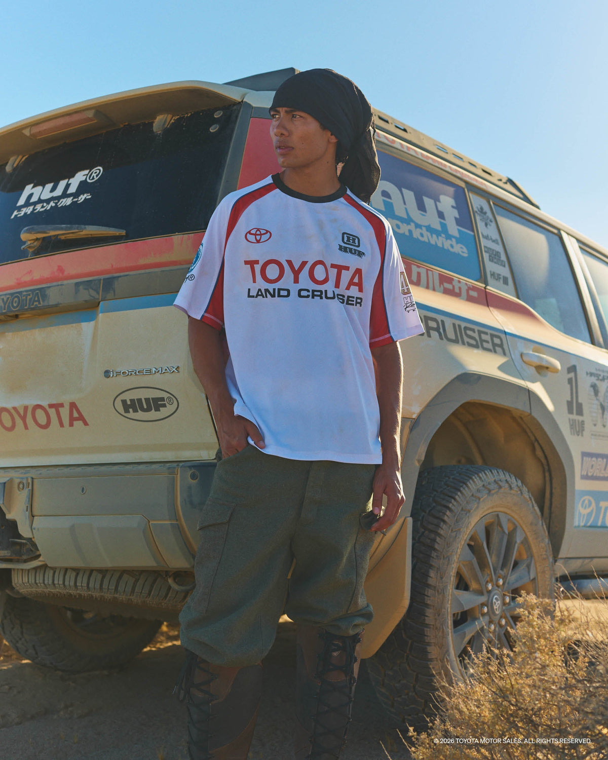 HUF × Toyota Land Cruiser Rally jersey on-model with dusty Land Cruiser — official campaign