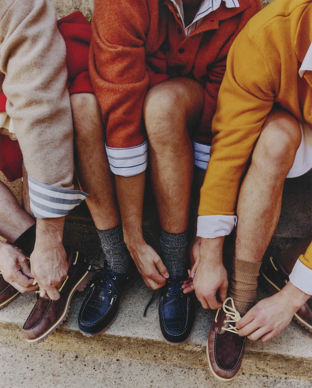 Jacquemus x Timberland La Bateau boat shoes on three people tying laces on steps. Photo via Fullress