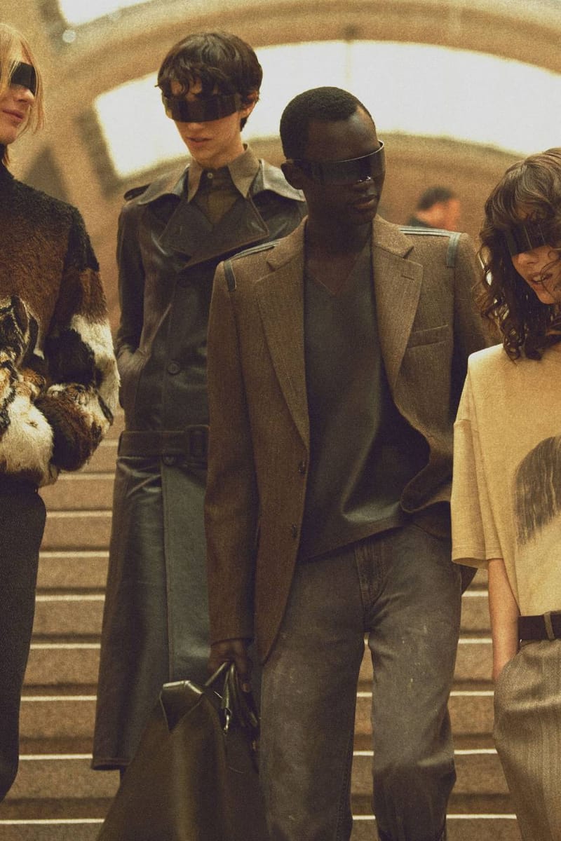 MM6 Maison Margiela FW26 campaign: models in leather trench, tweed blazer and shearling on the stairs at Milano Centrale, shot by Philippine Chaumont and Agathe Zaerpour. Photo via Hypebeast