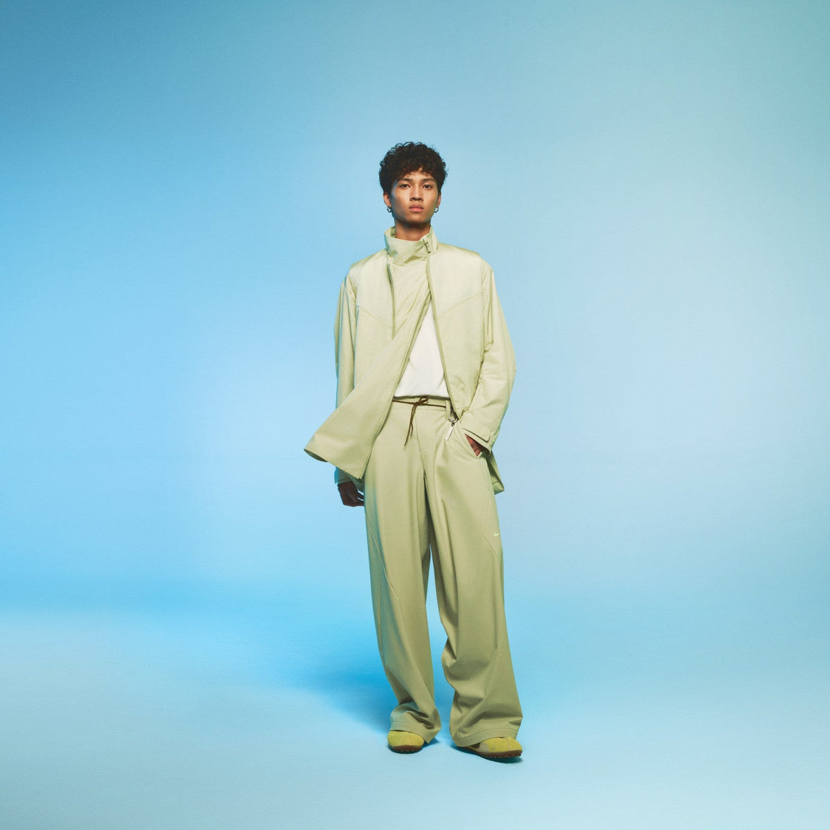 Nike Local Creation Collections look: sage modular jacket and wide pants on model. Photo via WWD / Nike