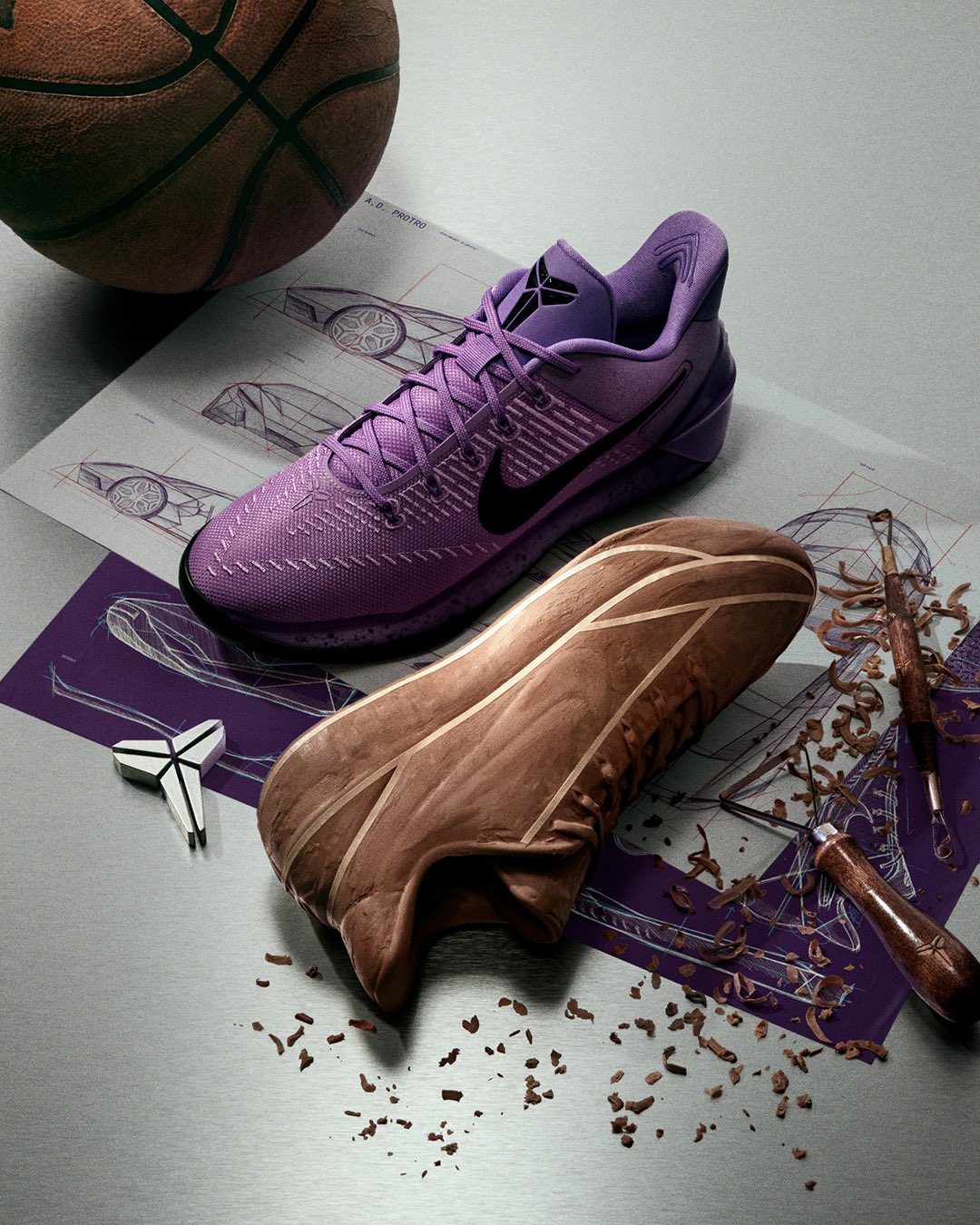Nike Kobe A.D. Protro in Purple Stardust next to a basketball, design sketches and a hand-carved clay model of the shoe, from the official Nike Basketball campaign