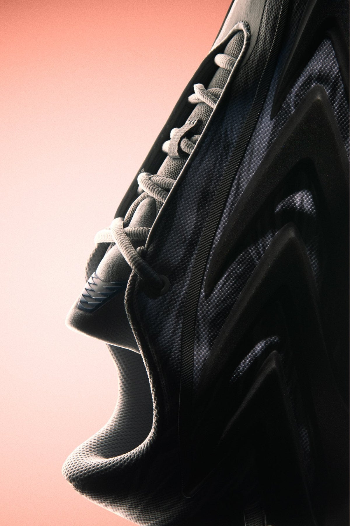Close-up of the adidas Anthony Edwards 3 “Snow Camo,” grey and white camo mesh with dark molded side panels and grey laces against a soft coral backdrop — official adidas Basketball image