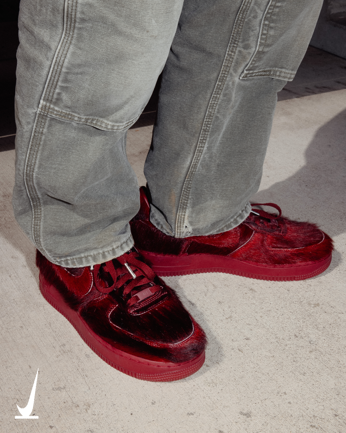 Nike Air Force 1 QS Team Red pony hair IR1940-600 on foot with grey work pants on concrete. Official Nike photo
