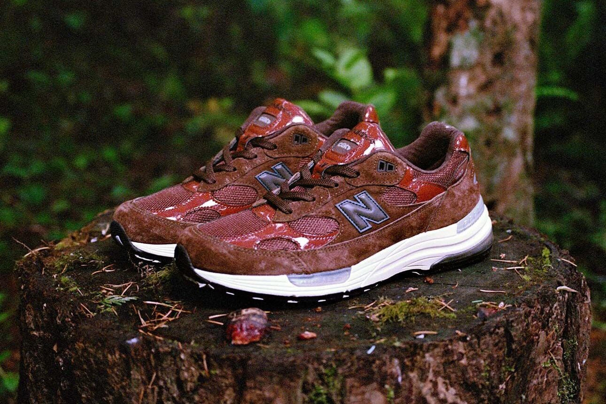Aminé x New Balance Made in USA 992 Outdoor School pair staged on a mossy forest tree stump