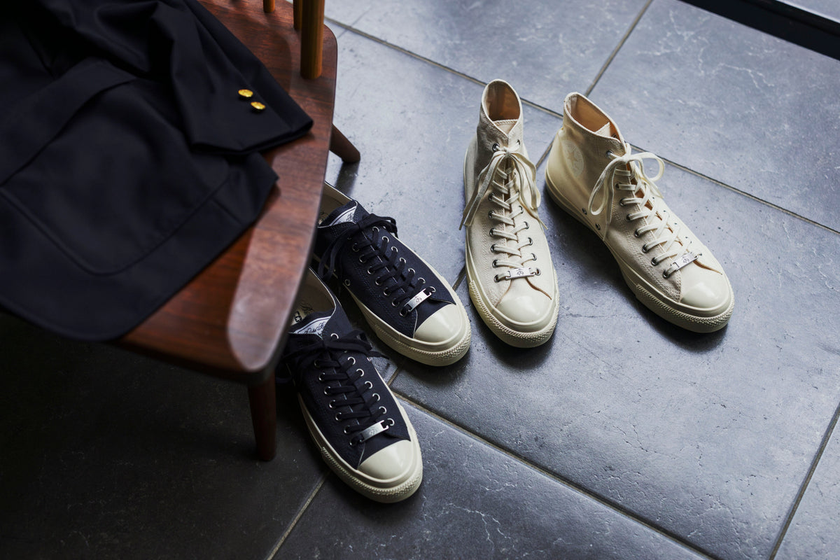 Brooks Brothers × Converse All Star Aged HI and OX styled on a stone floor beside a navy blazer — official Brooks Brothers Japan press image