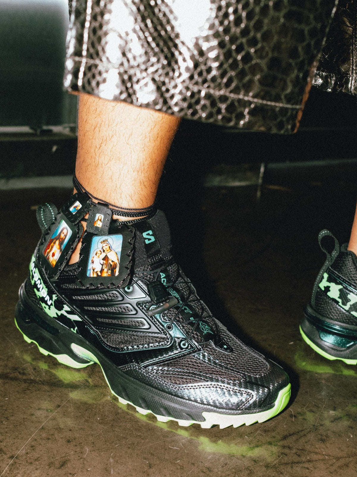 Feid on-foot in Salomon ACS NEXXT The Green Star — black/bright green with scapular charms — collaborator official look