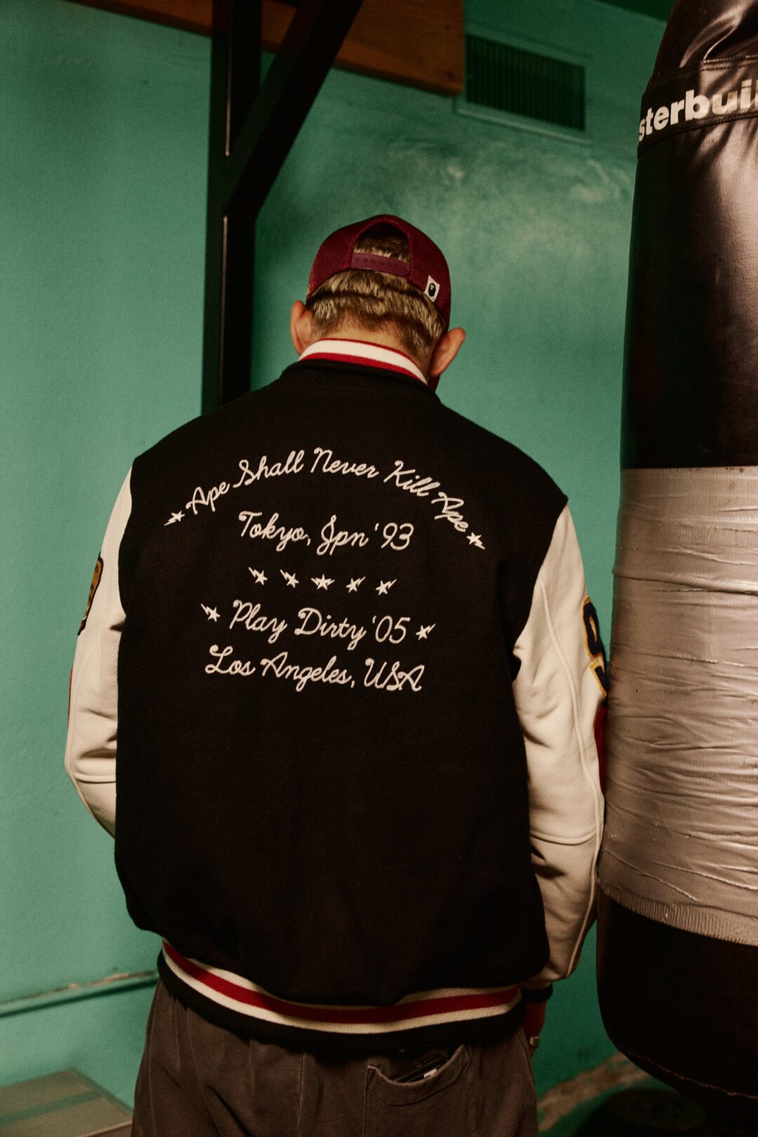 UNDEFEATED x BAPE FW26 varsity jacket back embroidered Ape Shall Never Kill Ape and Play Dirty. Photo via Fullress