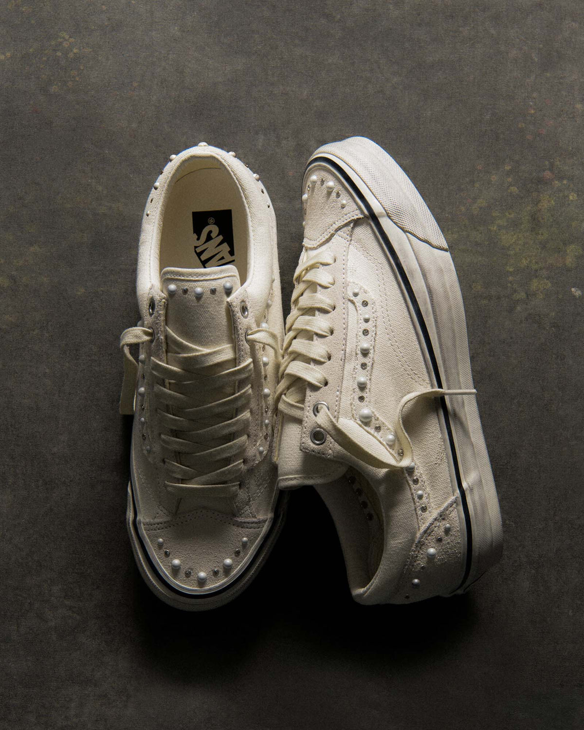Vans Premium Old Skool 36 Pearlized in Marshmallow, VN000ZB8CDA, with faux pearls and studs on the toe, Sidestripe and tongue on a dark textured surface — official Vans image