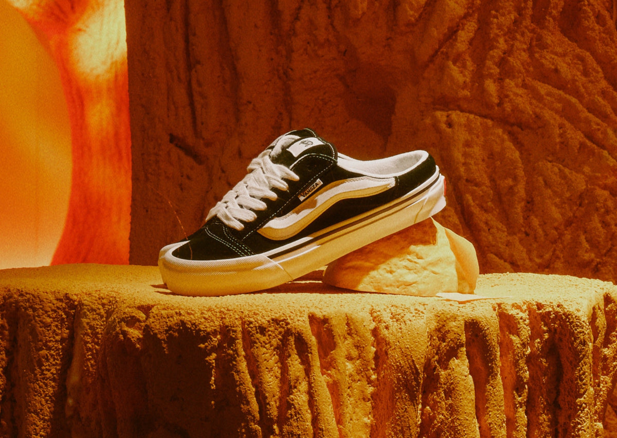 VANSZA Knu Skool Mule in black and white suede on a tree stump inside the orange forest set of the VANSZA pop-up. Photo via Sole Retriever